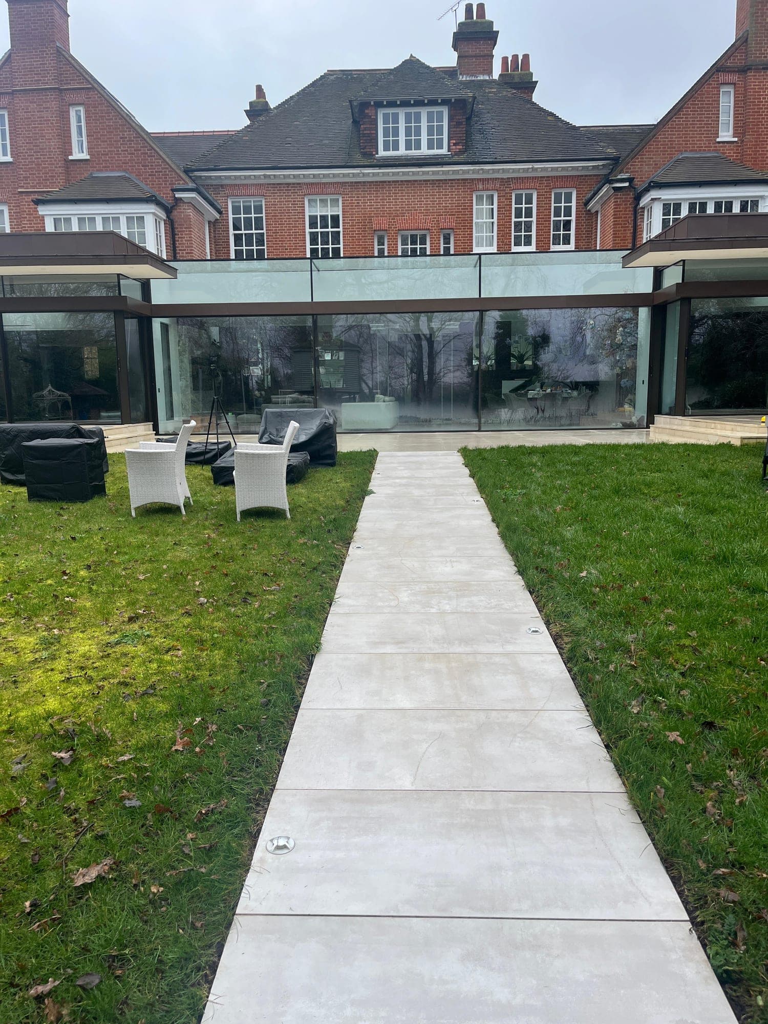 Large detached house with a modern glass extension and landscaped rear garden